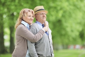 Carefree elderly couple hugging in park